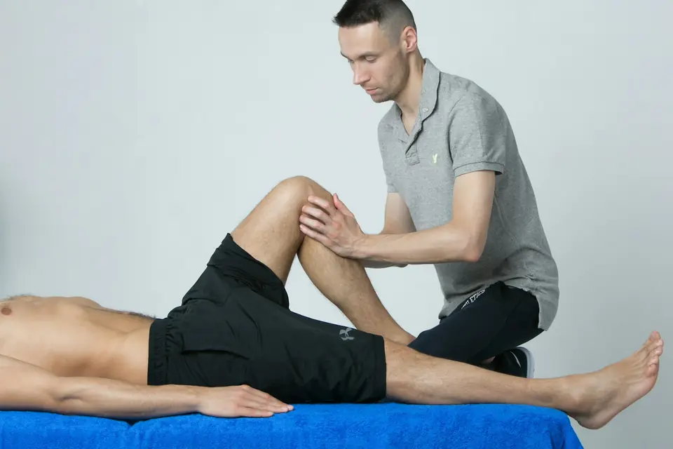 Fisioterapeuta tratando la rodilla de un paciente en camilla