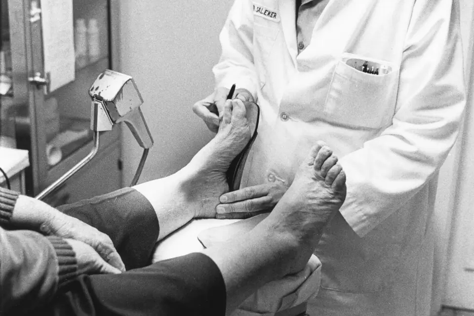 Profesional sanitario examinando el pie y el tobillo de un paciente